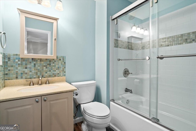 full bathroom with combined bath / shower with glass door, toilet, vanity, and backsplash