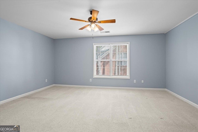 carpeted empty room featuring ceiling fan and baseboards