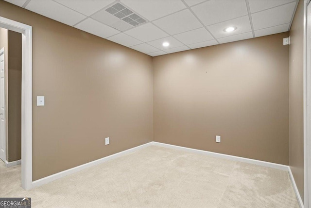 empty room with light colored carpet, baseboards, a drop ceiling, and recessed lighting
