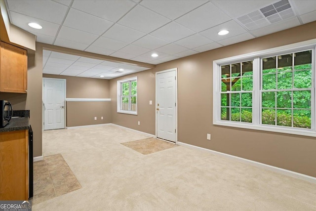 unfurnished living room with carpet floors, baseboards, a drop ceiling, and recessed lighting