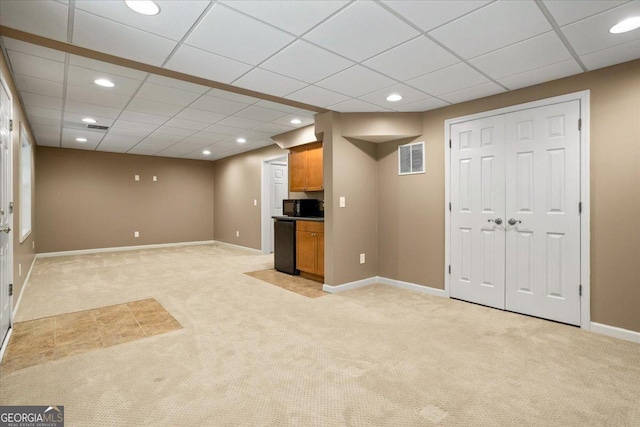 finished below grade area featuring light carpet, recessed lighting, baseboards, and a paneled ceiling