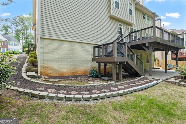 rear view of property with a patio, a wooden deck, and stairs