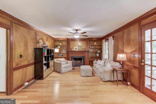 3741 Windhurst Dr SW, Lilburn, GA 30047 - living area featuring light wood-type flooring, a ceiling fan, a fireplace, built in shelves, and baseboards