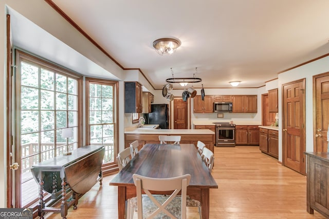 3741 Windhurst Dr SW, Lilburn, GA 30047 - dining space with crown molding, healthy amount of natural light, and light wood finished floors