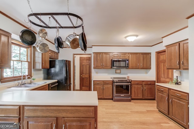 3741 Windhurst Dr SW, Lilburn, GA 30047 - kitchen featuring stainless steel appliances, a sink, light countertops, light wood-type flooring, and a peninsula