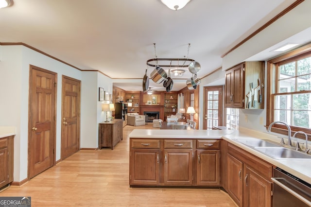 3741 Windhurst Dr SW, Lilburn, GA 30047 - kitchen featuring a sink, stainless steel dishwasher, ornamental molding, a fireplace, and light wood-style floors