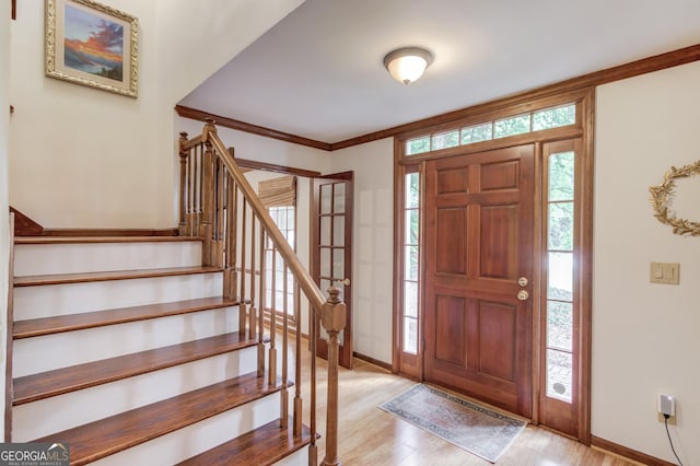 3741 Windhurst Dr SW, Lilburn, GA 30047 - entryway featuring light wood-style floors, baseboards, stairway, and ornamental molding