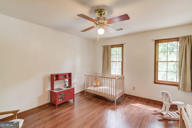 3741 Windhurst Dr SW, Lilburn, GA 30047 - bedroom featuring multiple windows, dark wood-style flooring, baseboards, and a ceiling fan