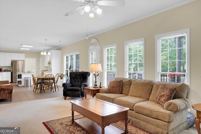 living area with a ceiling fan, light tile patterned floors, crown molding, and light colored carpet