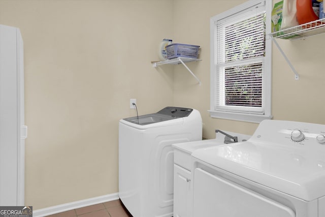 clothes washing area with washer and clothes dryer, tile patterned floors, and baseboards