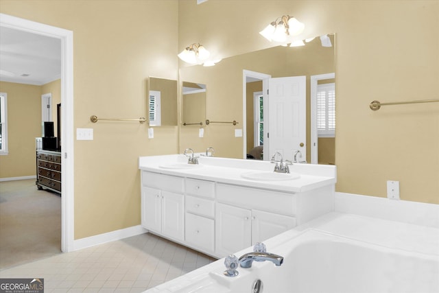 bathroom featuring ensuite bath, baseboards, double vanity, a bath, and ornamental molding
