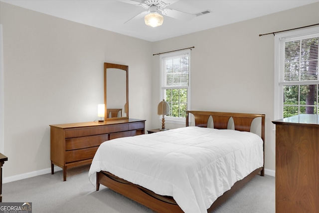bedroom featuring light carpet, baseboards, and a ceiling fan