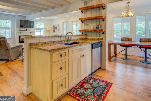 22 Waters Bridge Cir, Covington, GA 30014 - kitchen with stainless steel dishwasher, a sink, light wood-type flooring, open floor plan, and beam ceiling
