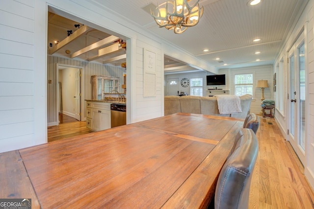 22 Waters Bridge Cir, Covington, GA 30014 - dining area featuring light wood-type flooring, a chandelier, recessed lighting, and wood walls