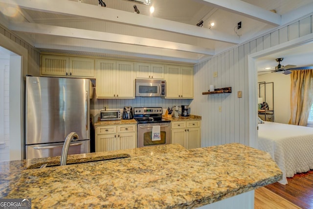 22 Waters Bridge Cir, Covington, GA 30014 - kitchen with stainless steel appliances, cream cabinetry, light wood-style flooring, beamed ceiling, and a sink
