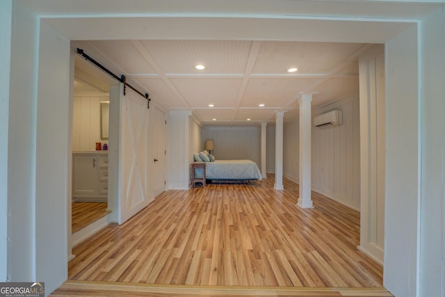 22 Waters Bridge Cir, Covington, GA 30014 - bedroom with a barn door, light wood-type flooring, a wall mounted air conditioner, recessed lighting, and baseboards