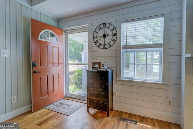 22 Waters Bridge Cir, Covington, GA 30014 - foyer with healthy amount of natural light, light wood-type flooring, wood walls, and baseboards