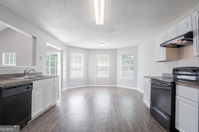 4915 Truitt Ln, Decatur, GA 30035 - kitchen featuring black appliances, under cabinet range hood, dark wood-type flooring, white cabinets, and healthy amount of natural light
