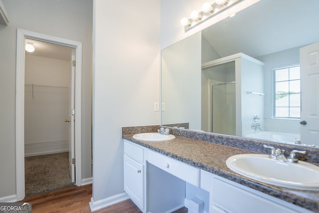 4915 Truitt Ln, Decatur, GA 30035 - full bathroom featuring a shower stall, double vanity, a walk in closet, wood finished floors, and a bath