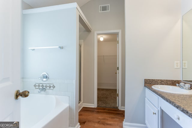4915 Truitt Ln, Decatur, GA 30035 - bathroom featuring vanity, a bath, a spacious closet, a shower stall, and wood finished floors