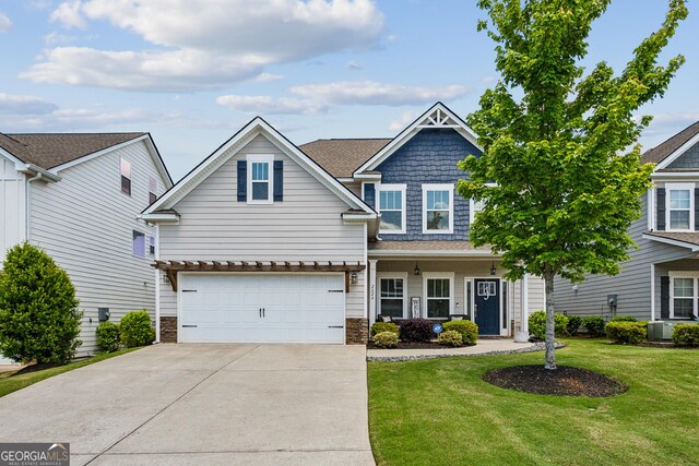 view of front of house with concrete driveway, an attached garage, a front yard, and cooling unit
