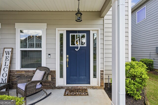 property entrance with stone siding and covered porch