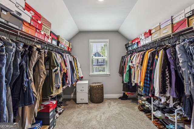 spacious closet with vaulted ceiling and carpet floors