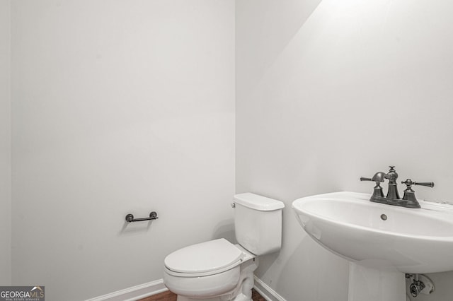 7280 Wright Dr, Atlanta, GA 30349 - half bathroom featuring baseboards and toilet