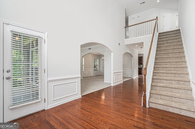 7280 Wright Dr, Atlanta, GA 30349 - entrance foyer featuring arched walkways, wood finished floors, stairway, a decorative wall, and wainscoting