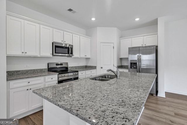 630 Evergreen Rd, Winder, GA 30680 - kitchen featuring appliances with stainless steel finishes, a sink, white cabinetry, a center island with sink, and recessed lighting