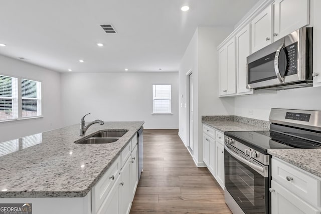 630 Evergreen Rd, Winder, GA 30680 - kitchen with appliances with stainless steel finishes, a sink, white cabinets, a center island with sink, and wood finished floors