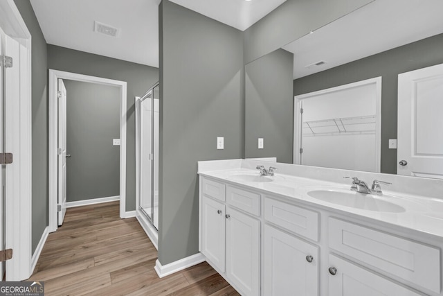 630 Evergreen Rd, Winder, GA 30680 - full bath with wood finished floors, a stall shower, double vanity, and baseboards