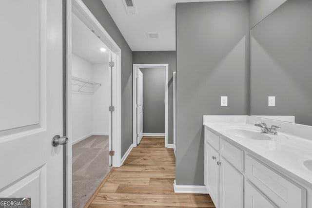 630 Evergreen Rd, Winder, GA 30680 - bathroom featuring baseboards, wood finished floors, double vanity, and a spacious closet