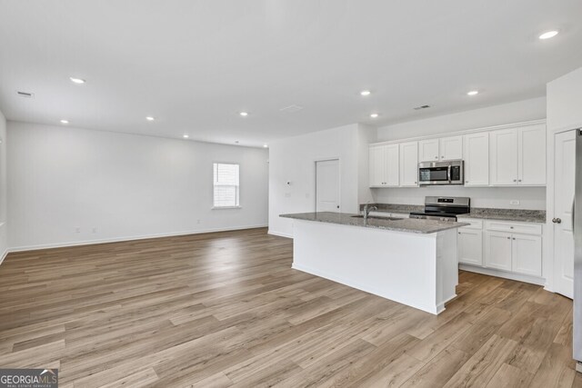 630 Evergreen Rd, Winder, GA 30680 - kitchen with appliances with stainless steel finishes, a sink, white cabinetry, light wood-style floors, and light stone counters