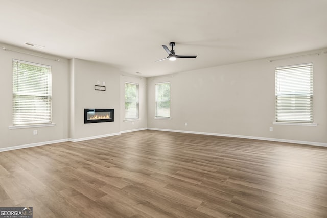 116 Cabin Way, Hampton, GA 30228 - unfurnished living room featuring healthy amount of natural light, wood finished floors, and a ceiling fan
