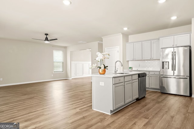 116 Cabin Way, Hampton, GA 30228 - kitchen featuring appliances with stainless steel finishes, a ceiling fan, a sink, open floor plan, and light wood-style floors