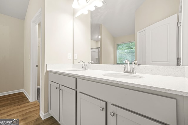 116 Cabin Way, Hampton, GA 30228 - bathroom featuring lofted ceiling, double vanity, wood finished floors, and baseboards