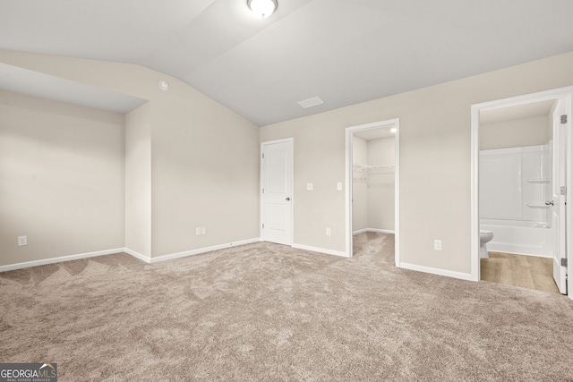 116 Cabin Way, Hampton, GA 30228 - unfurnished bedroom featuring carpet floors, vaulted ceiling, a walk in closet, baseboards, and a closet