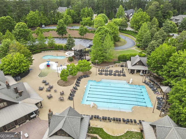 bird's eye view of a pool and a tree filled landscape