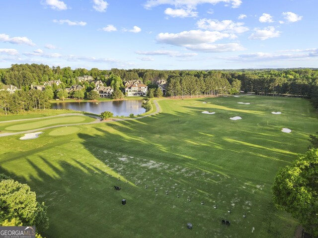 view of property location featuring a local golf course and a nearby body of water