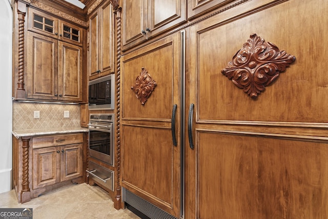 kitchen featuring oven, a warming drawer, black microwave, backsplash, and light stone counters