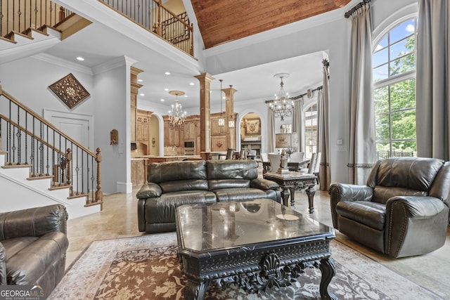 living room featuring a chandelier, a high ceiling, ornamental molding, arched walkways, and stairway