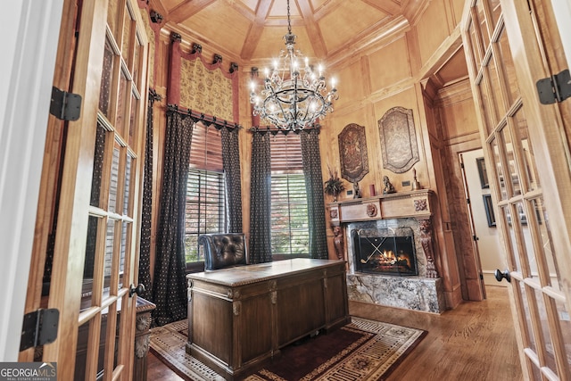 office featuring coffered ceiling, a chandelier, crown molding, french doors, and a fireplace