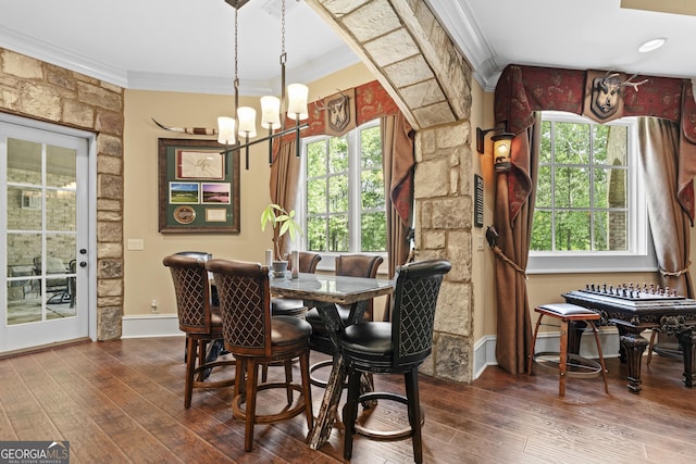 dining area with ornamental molding, a chandelier, dark wood-style floors, and baseboards