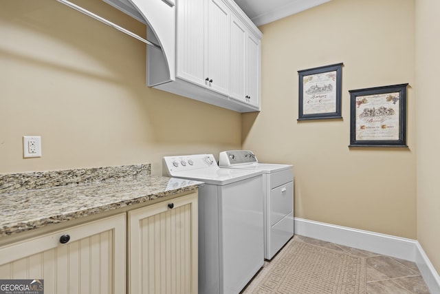 washroom with washing machine and clothes dryer, cabinet space, baseboards, and light tile patterned floors