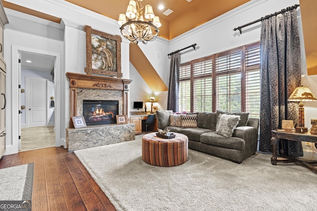 living area featuring a chandelier, hardwood / wood-style floors, a fireplace, and recessed lighting