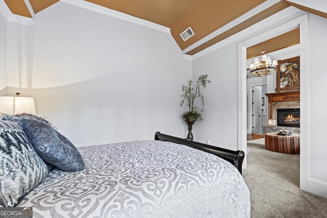 bedroom with carpet, a chandelier, and a warm lit fireplace