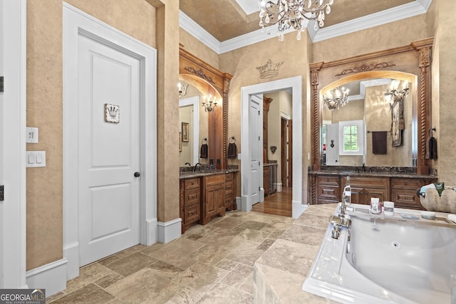 full bathroom with a chandelier, crown molding, stone tile flooring, two vanities, and a tub with jets