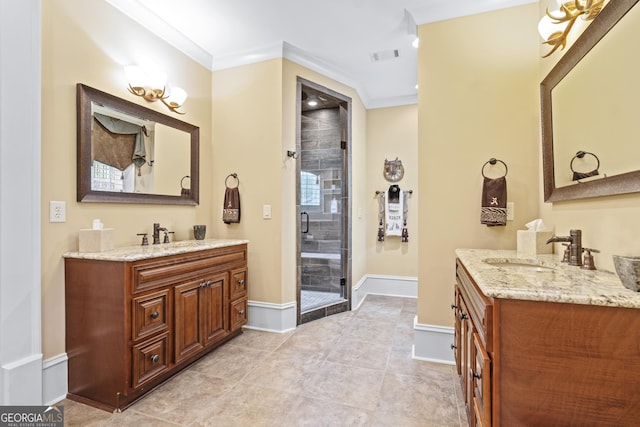 full bath featuring two vanities, a stall shower, baseboards, crown molding, and tile patterned floors