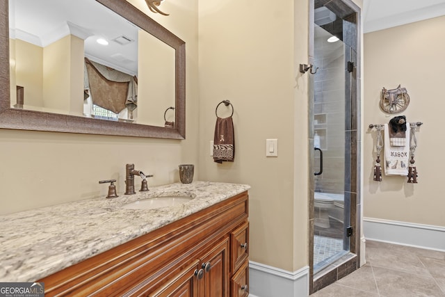 bathroom featuring a stall shower, vanity, baseboards, ornamental molding, and tile patterned flooring
